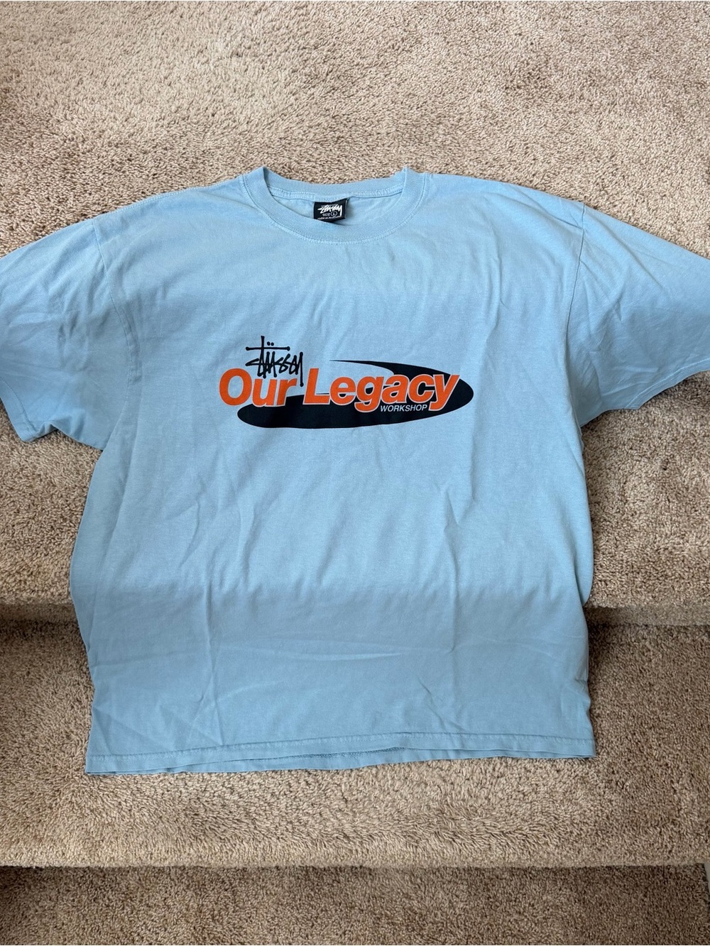 Stussy Light Blue "Our Legacy" Short Sleeve Tee with Orange & Black Print